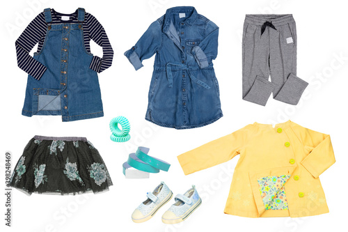 Collage set of little girl autumn clothing isolated on a white background. The collection of a blue denim overall, t-shirt, jeans dress, rain coat, skirt, sweat pants and shoes and accessories.