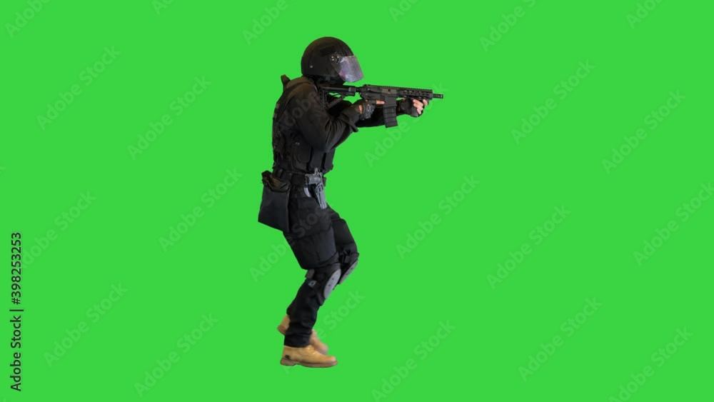 Masked Squad Member of Armed SWAT Police Walking And Aming With a Rifle on a Green Screen, Chroma Key. Masked Squad Member of Armed SWAT Police Walking And Aming With a Rifle on a Green Screen, Chroma Key.