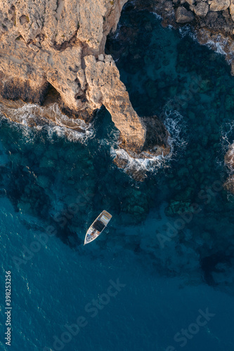 Boat near the cliffs in blue water sea in Cyprus