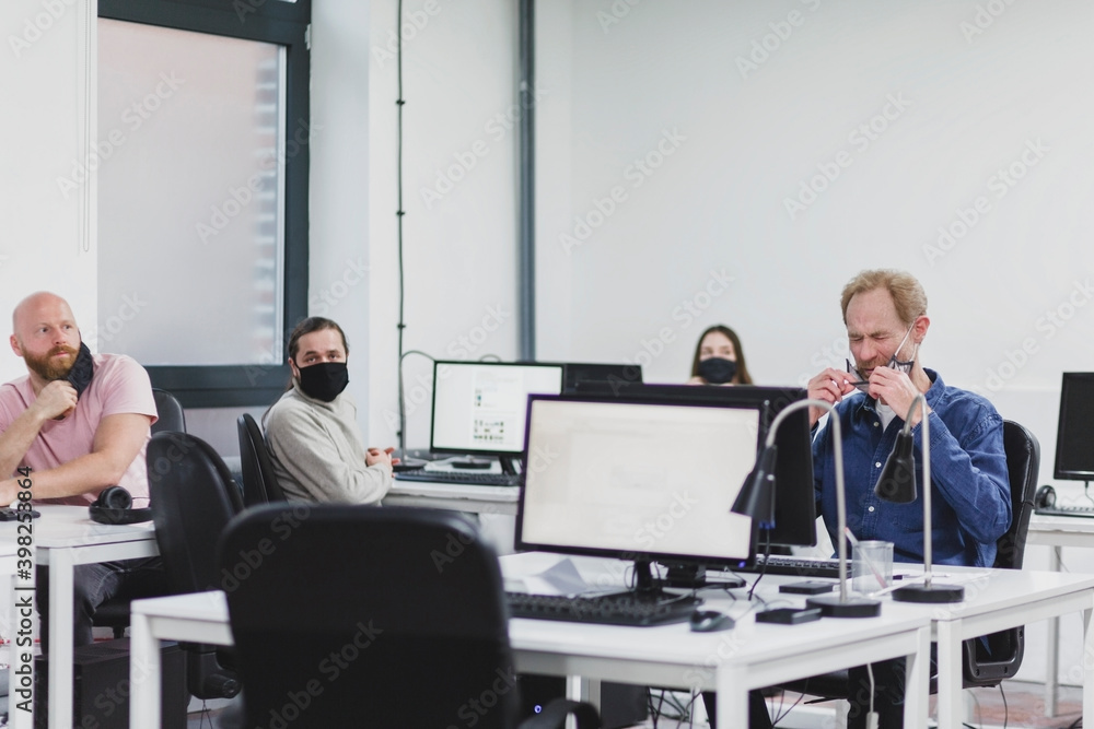 Workers wearing face masks in office Workers wearing face masks in office