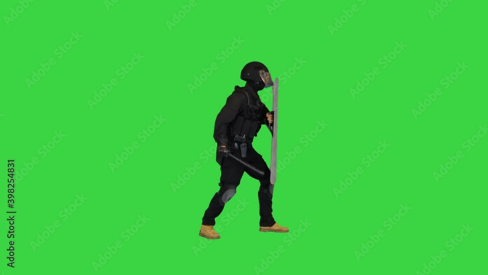 Special unit policeman running into the frame, holding shield up and hitting it with the baton for intimidation on a Green Screen, Chroma Key. Special unit policeman running into the frame, holding shield up and hitting it with the baton for intimidation on a Green Screen, Chroma Key.