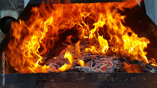 Empty flaming charcoal grill with an open fire  for cooking the product. The fiery background.