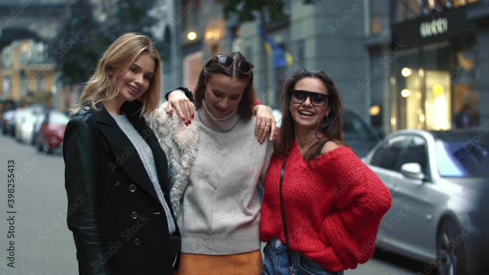 Three girls are walking down the street Three girls are walking down the street