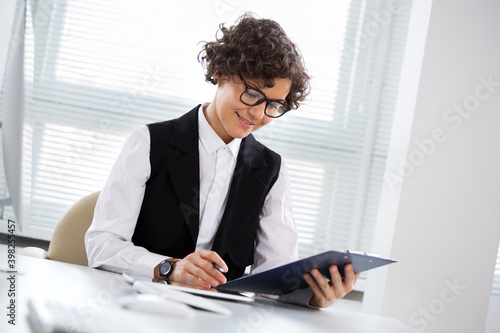 Portrait of a business woman with glasses at workplace in office