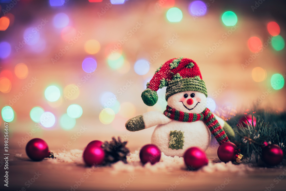 cheerful snowman in knit hat and Christmas decorations on festiv