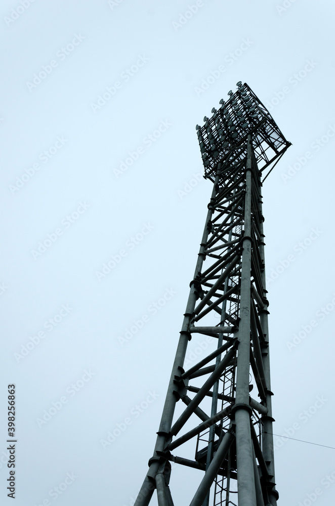 High metal stadium light against dark day sky.Vertical image