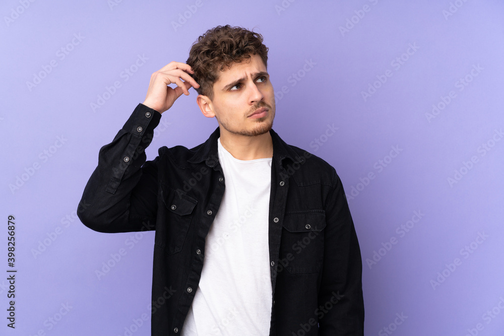 Caucasian man isolated on purple background having doubts while scratching head Caucasian man isolated on purple background having doubts while scratching head