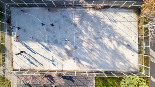 aerial view of street basketball court and children playground. kids are playing football at the sunset.