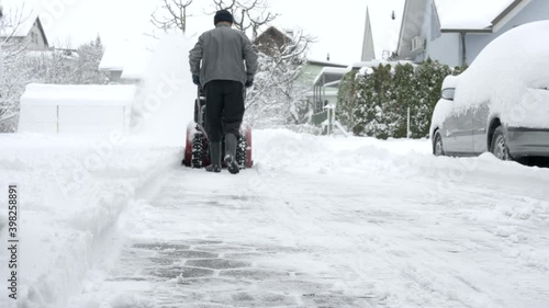 Man clearing snow from his driveway with a snow blower