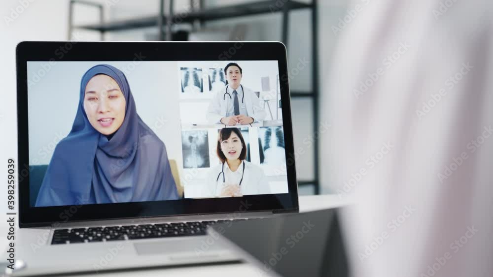 Young Asia female doctor in white medical uniform with stethoscope using computer laptop talking video conference call with patient at desk in health clinic or hospital. Consulting and therapy concept Young Asia female doctor in white medical uniform with stethoscope using computer laptop talking video conference call with patient at desk in health clinic or hospital. Consulting and therapy concept