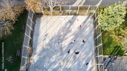 aerial view of street basketball court and children playground. kids are playing football at the sunset.