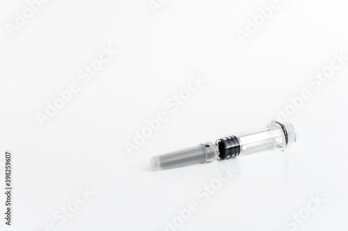 A syringe with a needle and a cap for medical vaccination on a light background lies on the table. copy space.