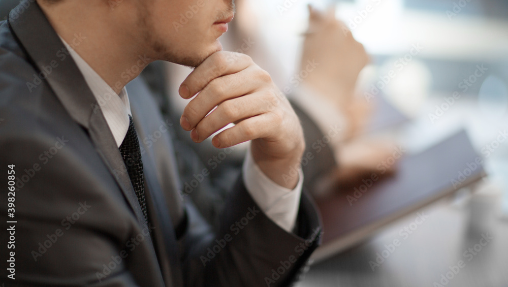 thoughtful young businessman sitting at his Desk. close up. thoughtful young businessman sitting at his Desk. close up.