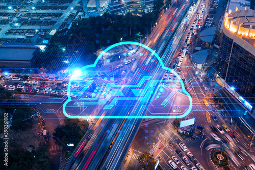 Storage cloud hologram on top view of road, busy urban traffic highway at night. Junction network of transportation infrastructure. The concept storing digital information. Double exposure.