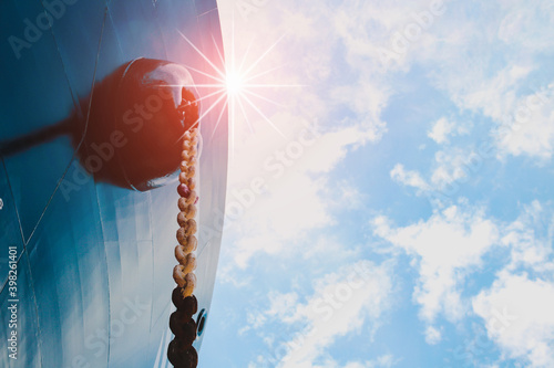 Front View ship with anchor center forecastle deck of commercial ship floating in port against sun light sky
