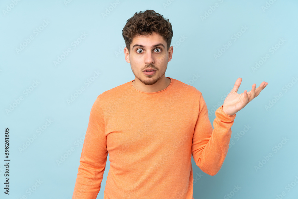 Caucasian man isolated on blue background making doubts gesture Caucasian man isolated on blue background making doubts gesture