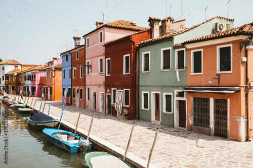 Panoramic view of coloured homes and water canal with boats in Burano