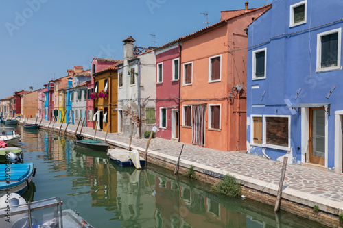 Panoramic view of coloured homes and water canal with boats in Burano