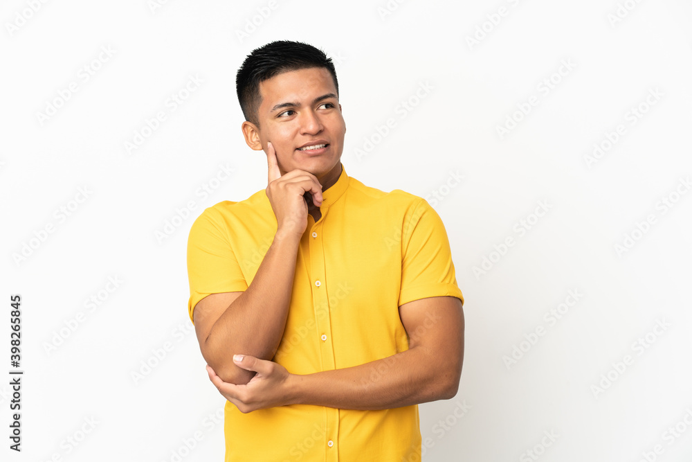 Young Ecuadorian man isolated on white background thinking an idea while looking up Young Ecuadorian man isolated on white background thinking an idea while looking up