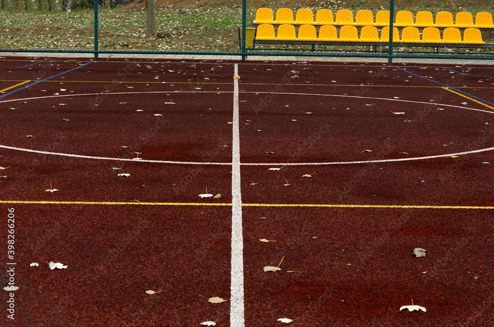 Fototapeta premium Empty sports ground, white and yellow lines on it, plastic yellow seats.Empty space