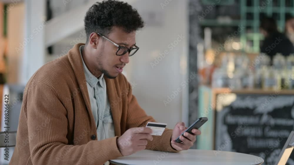 African Man Excited by Successful Online Shopping on Smartphone African Man Excited by Successful Online Shopping on Smartphone