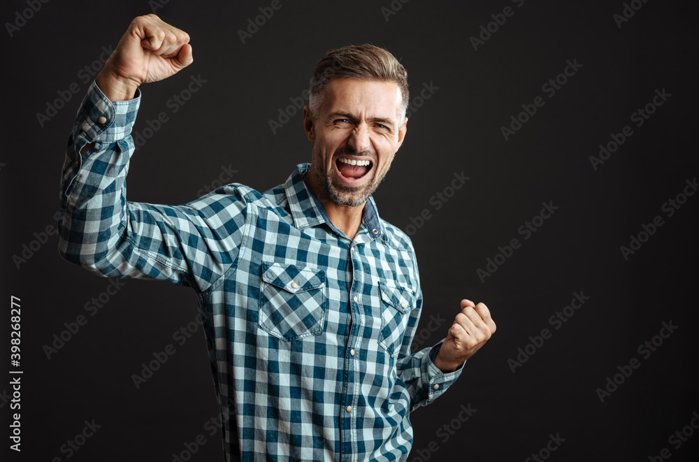 Excited grey-haired man showing winner gesture Excited grey-haired man showing winner gesture