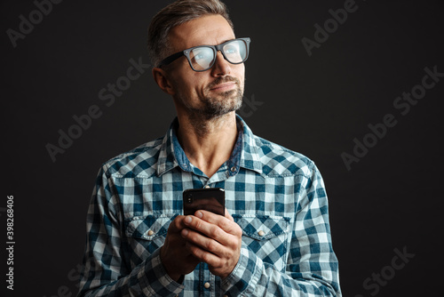 Man using mobile phone isolated over grey wall background