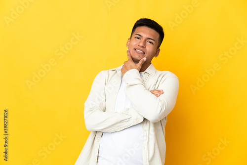 Young Ecuadorian man isolated on yellow background happy and smiling