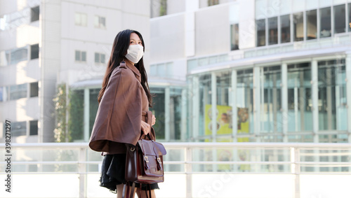 Asian woman wearing mask in the city / winter 2020-2021