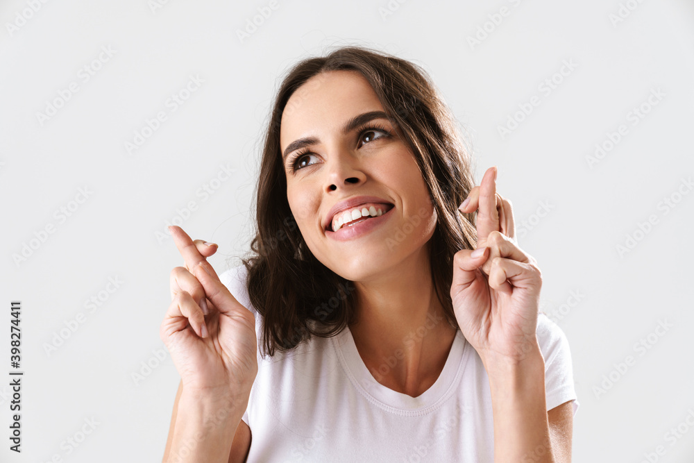 Happy beautiful nice girl holding fingers crossed for good luck Happy beautiful nice girl holding fingers crossed for good luck