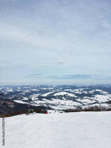 Beautiful natural landscape with mountains covered with snow. Landscape picture of ski resort and ski lift from top. Active recreation in the mountains. Isolation concept during quarantine.