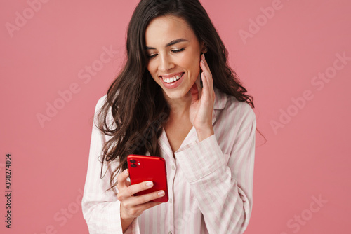 Cheerful beautiful woman laughing while using mobile phone