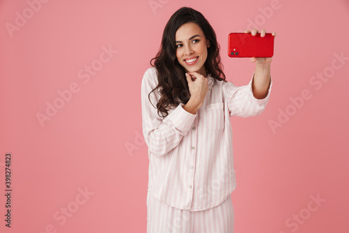 Cheerful beautiful woman taking selfie on mobile phone