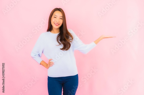 Portrait beautiful young asian woman smile with action on pink background