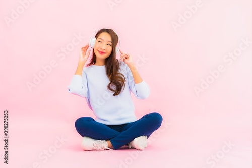 Portrait beautiful young asian woman use smart mobile phone with headphone