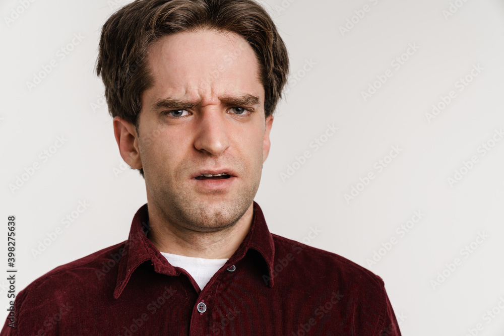 Handsome displeased guy posing and looking at camera Handsome displeased guy posing and looking at camera