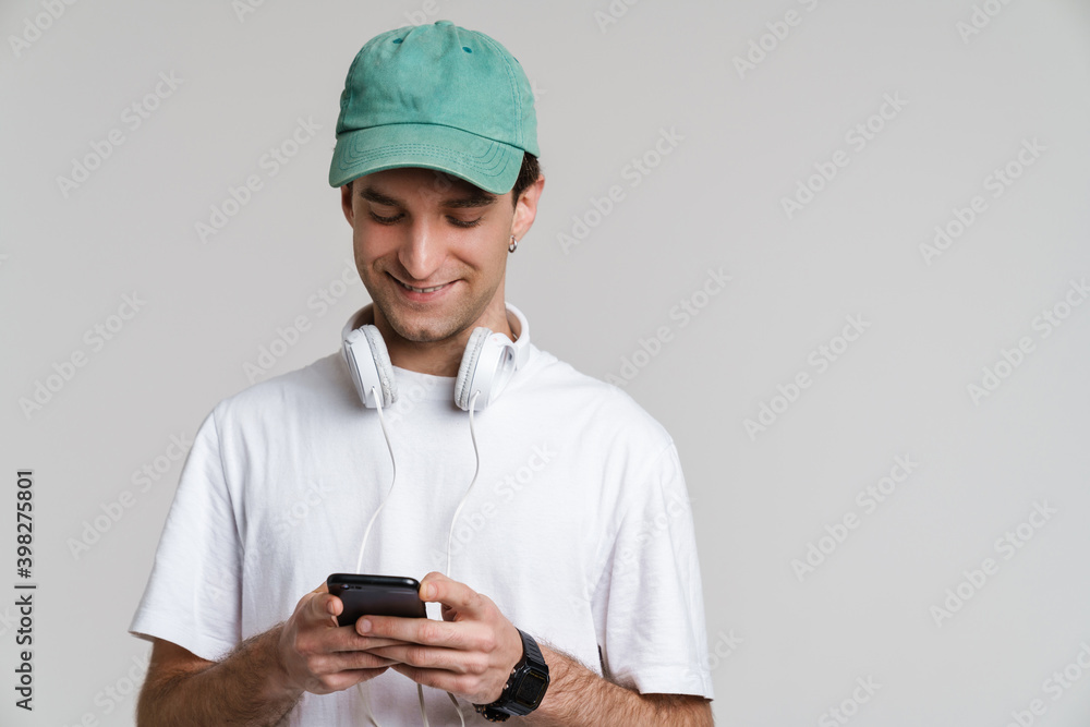 Handsome smiling guy with headphones using mobile phone Handsome smiling guy with headphones using mobile phone