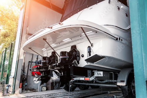 Slika na platnu Big luxury cabin motorboat cruiser yacht engine at trailer ramp from storage boat hangar garage