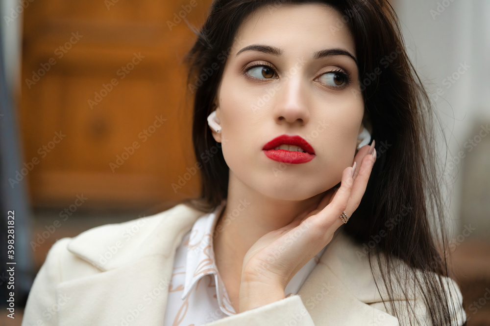 Portrait of a girl model with white headphones in her ears. Portrait of a girl model with white headphones in her ears.