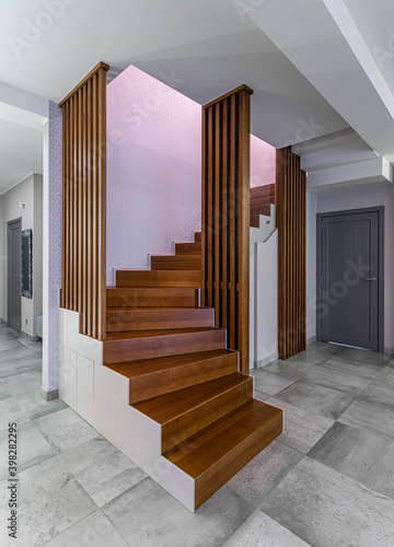 Wooden staircase in luxury apartment. Modern interior of flat.