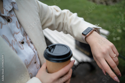 Smart watch and coffee in the hands of a girl