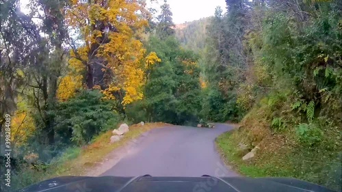 4x4 SUV driving through narrow and steep roads of wildlife sanctuary in mountains. View through dash camera.