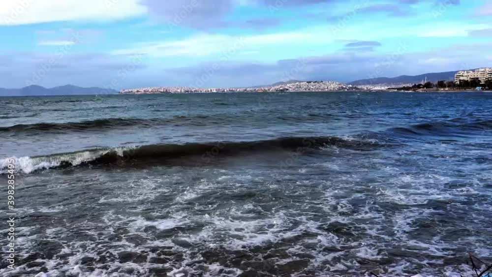 Waves in the sea on a windy day, with a view of Piraeus, Greece Waves in the sea on a windy day, with a view of Piraeus, Greece