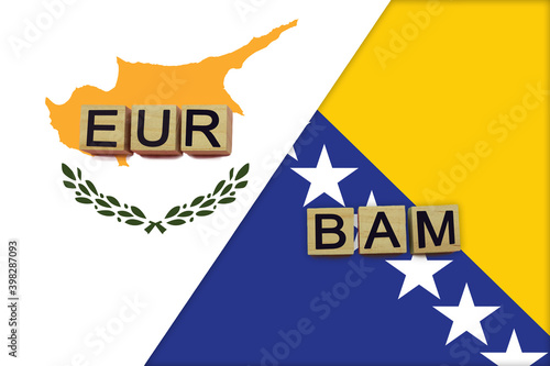 Cyprus and Bosnia currencies codes on national flags background photo