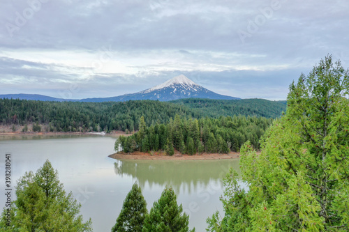 Peaceful lake in the forest with a mountain as background © Christian