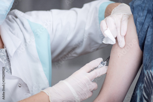 Close-up hands,nurses are vaccinations to patients using the syringe.Doctor vaccinating women in hospital.Are treated by the use of sterile injectable upper arm. injection,antibody,influenza vaccine © Денис Прокофьев