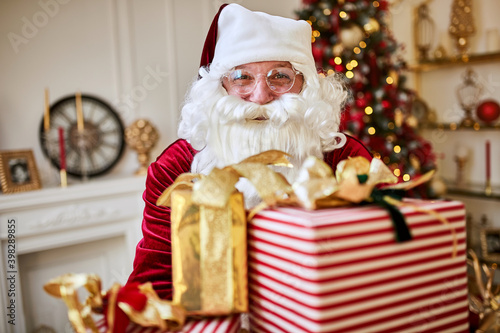 Happy Santa Claus brought many gifts to children.  New year and Merry Christmas holidays concept