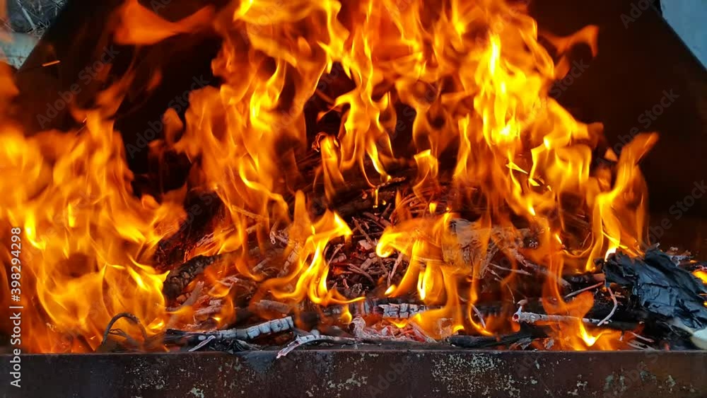 Empty flaming charcoal grill with an open fire, for cooking the product. The fiery background.