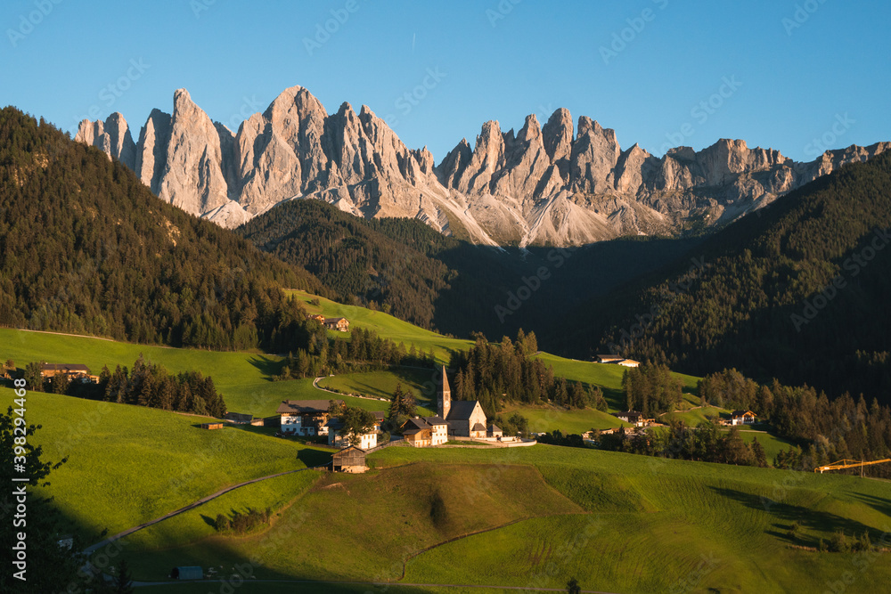 Beautiful view of the Puez Odle National Park and the Santa Magdalena Church at sunset, Dolomites, Italy