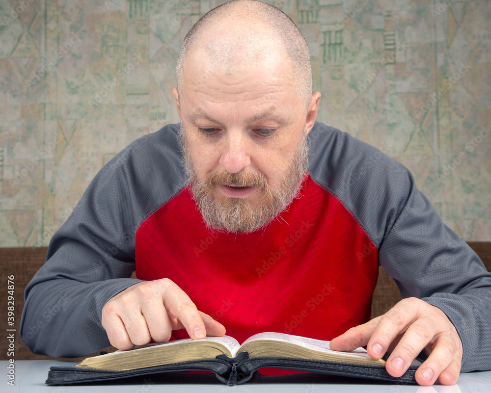 happy bearded man studies the Bible. religion and Christianity happy bearded man studies the Bible. religion and Christianity
